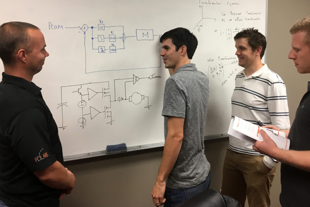 Imagen de ingenieros de pie en una pizarra